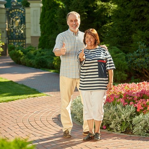 smiling-senior-couple-in-front-of-olympia-home.jpg